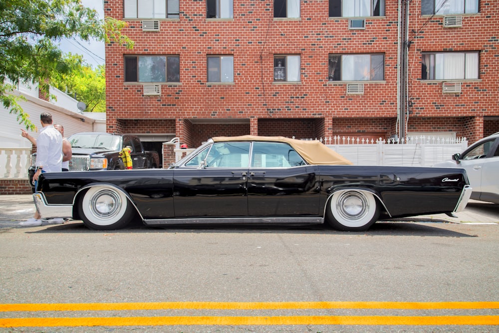 black sedan parked beside concrete building