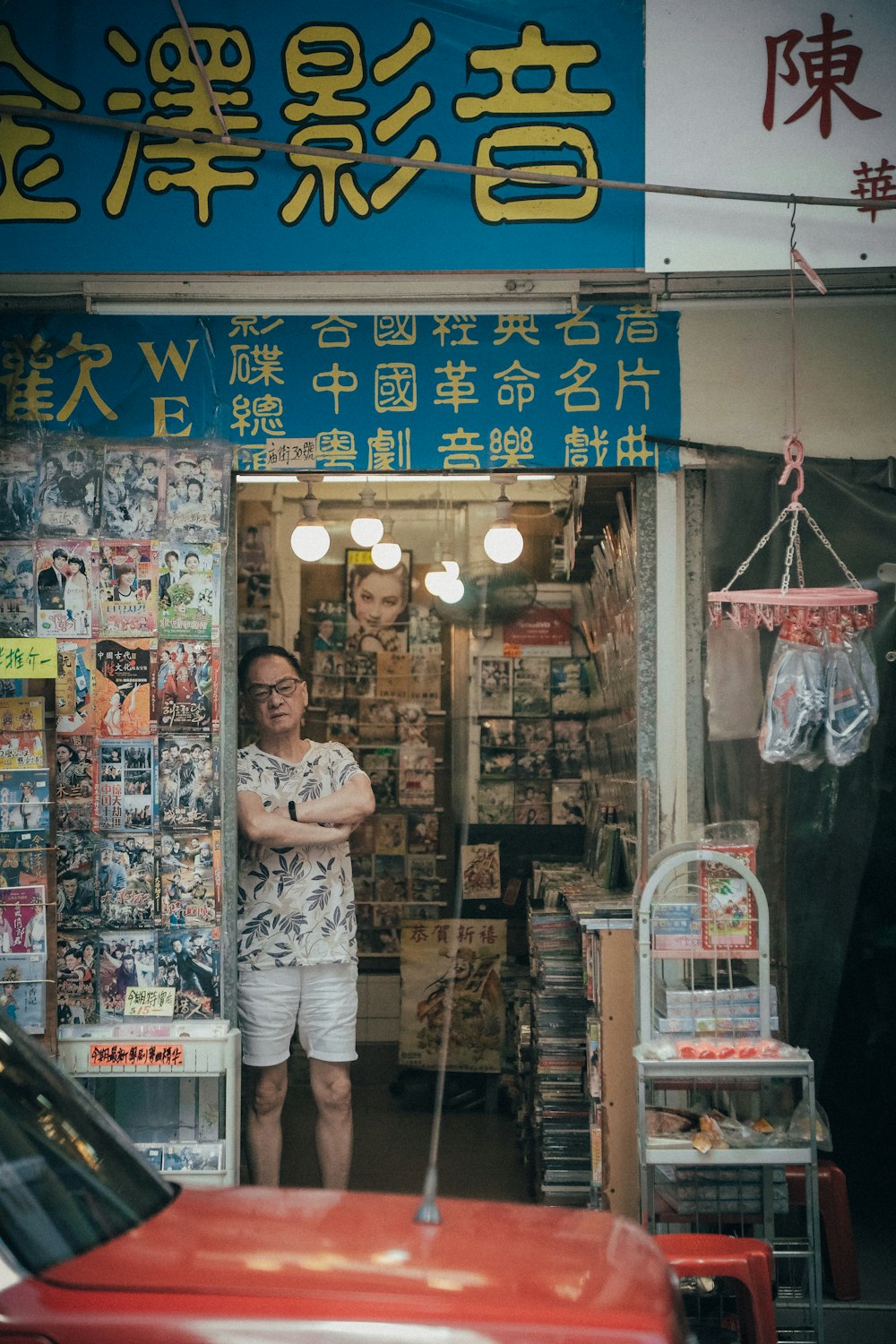 man standing beside assorted-title DVD case lot