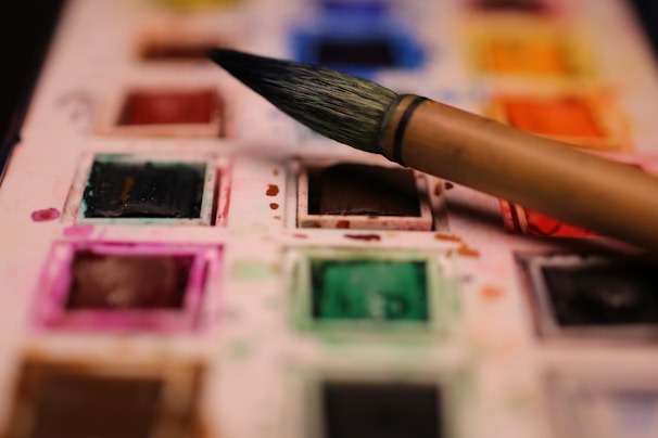 A close-up shot of a palette with mixed watercolor paints in various shades.