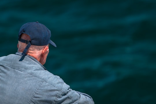 man looking on body of water wearing black cap in Port Stephens Australia
