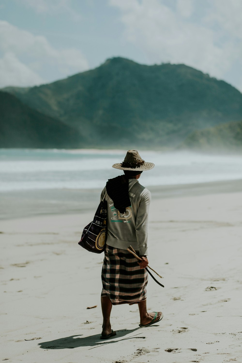 man walking on shore under sunny sky