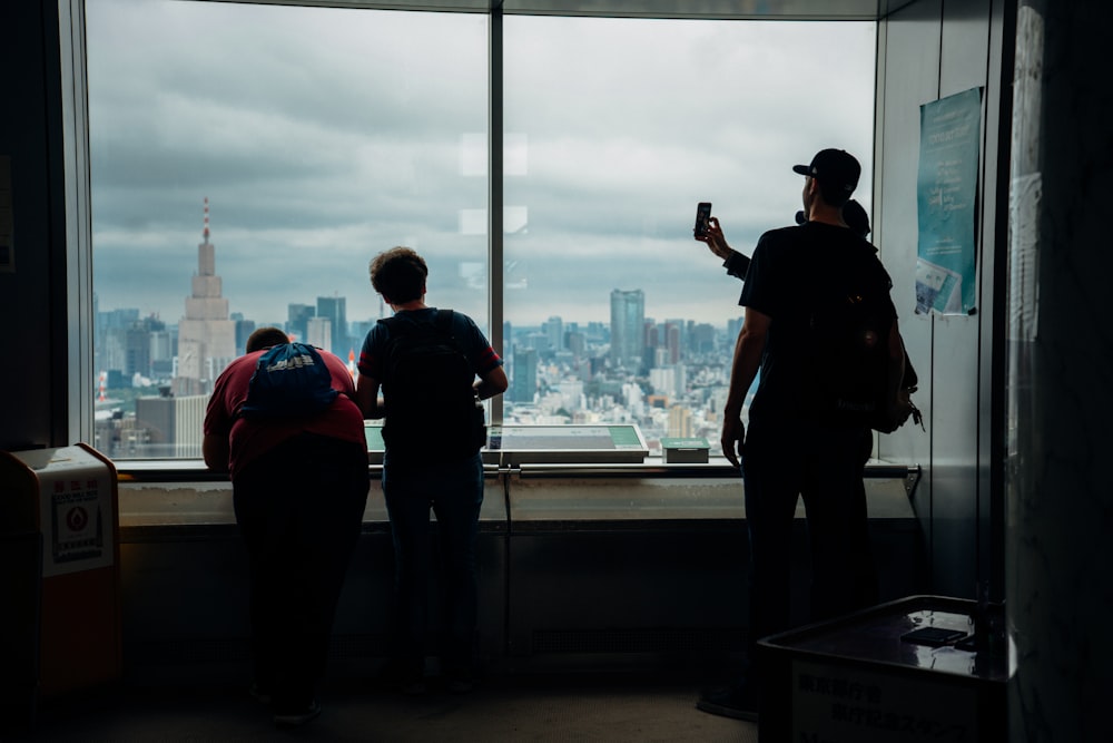 a group of people standing in front of a window