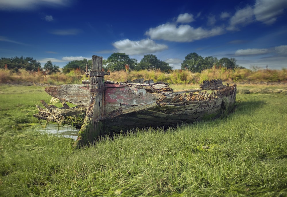 wrecked wooden boat on grass