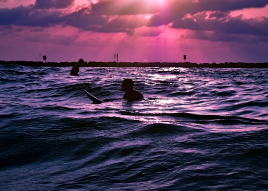 silhouette of person surfing on sea during sunset in Tel Aviv-Yafo Israel