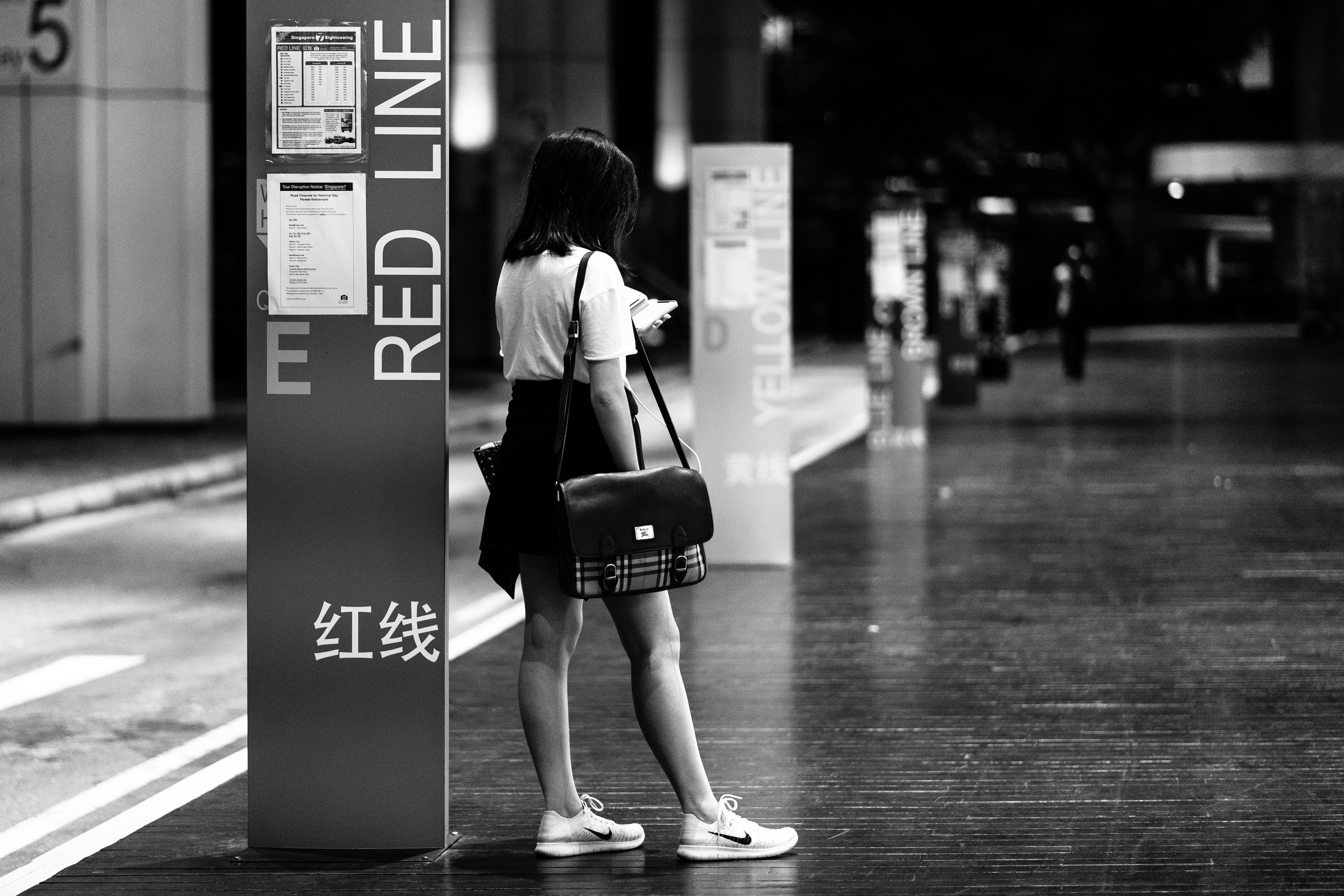 donna che porta borsa a tracolla accanto alla segnaletica del pavimento