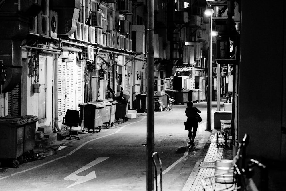 grayscale photo of person walking on street