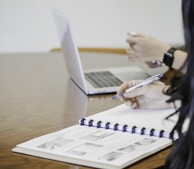 person holding pen writing on paper