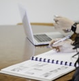 person holding pen writing on paper