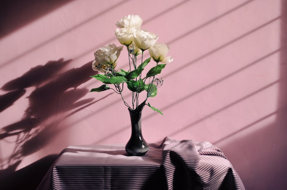 white artificial flowers in black vase