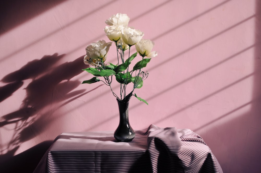 fleurs artificielles blanches dans un vase noir