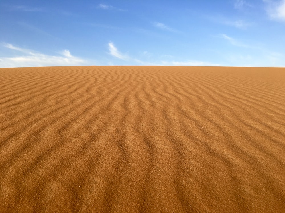 Brauner Sand unter blau-weißem Himmel