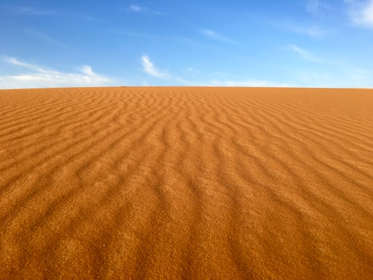 brown sand under blue and white sky in Erg Chebbi Morocco
