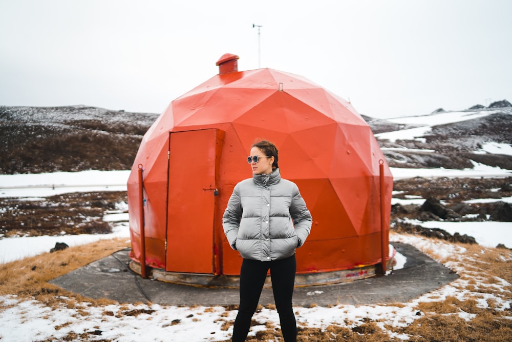 woman wearing black pants near red metal dome house