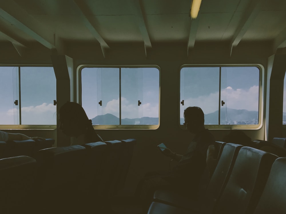 man sitting on chair beside window