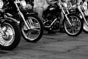 A lineup of motorcycles parked in a row, sharply detailed on a white background.