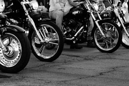 A lineup of motorcycles parked in a row, sharply detailed on a white background.