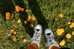 A happy customer showing off their new stylish sneakers from pasoperfecto in a sunny park