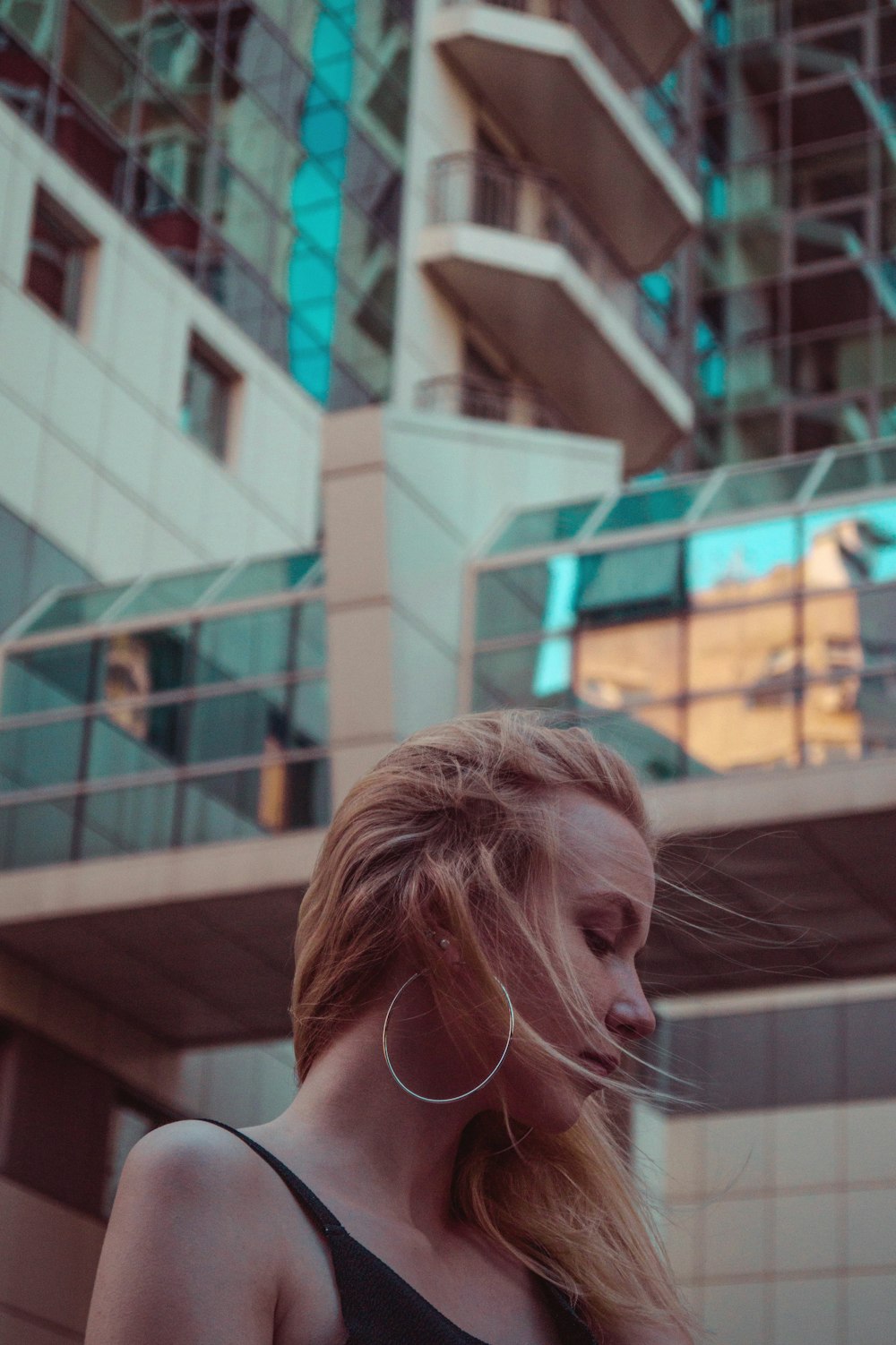 woman wearing black spaghetti strap top near high-rise building