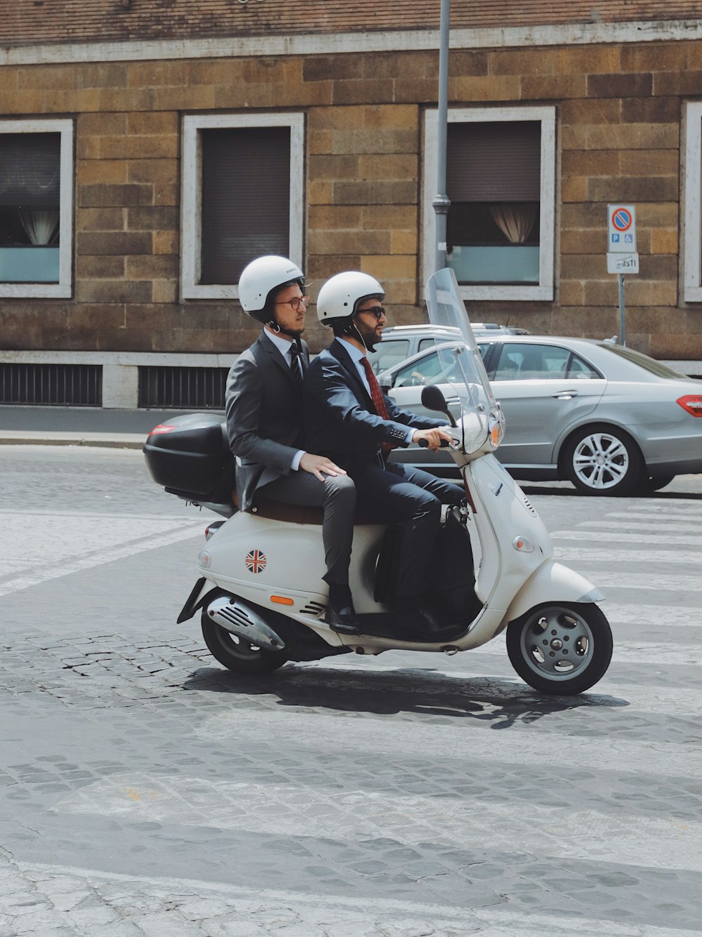 two men riding on motor scooter