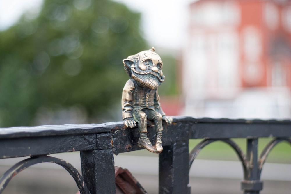 man figurine on grey wooden handrail