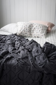 closeup photo of gray comforter on bed
