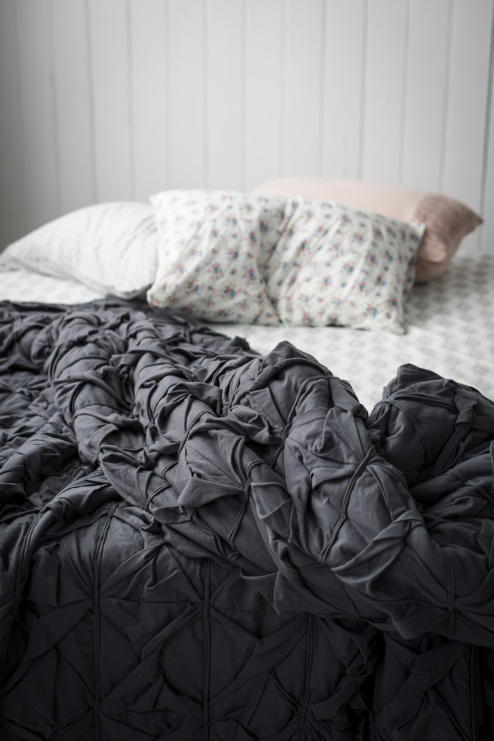 Nahaufnahme der grauen Bettdecke auf dem Bett