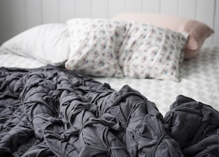 closeup photo of gray comforter on bed