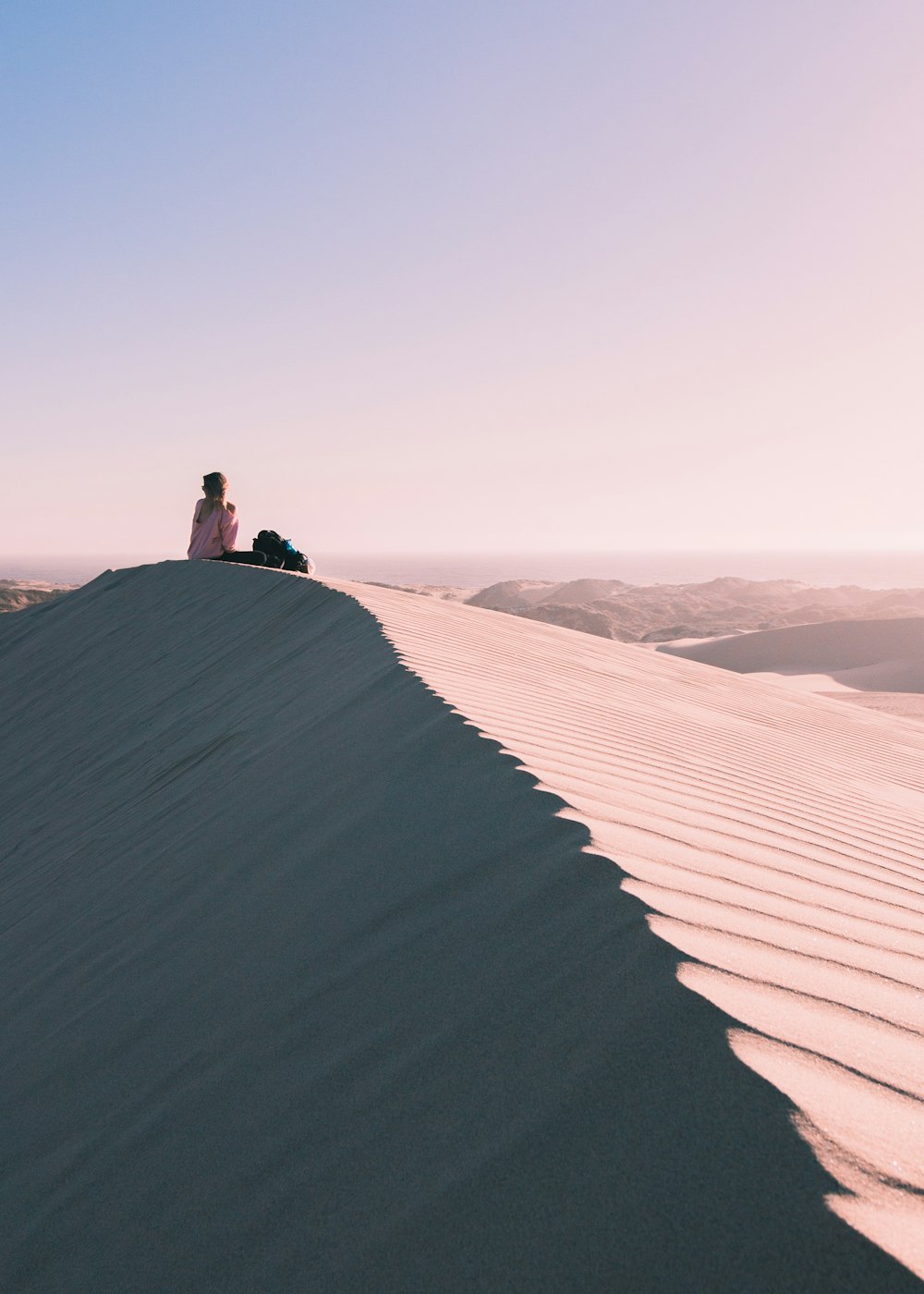 rule of thirds photography of person sitting on desert