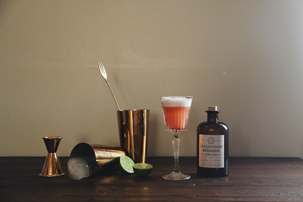 brass-colored cocktail shaker near bottle