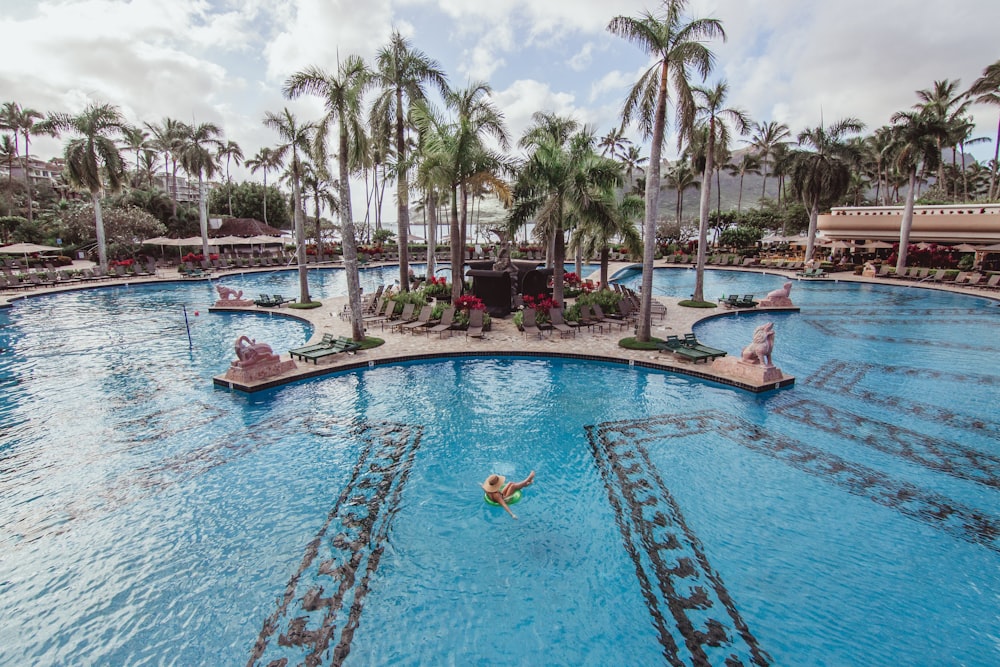 person floating on pool at daytime