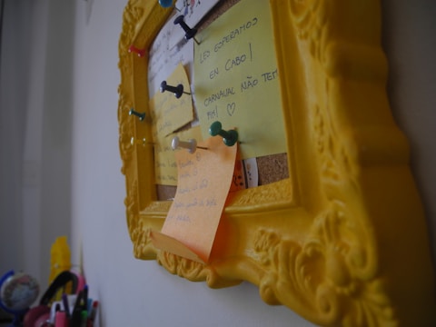 A colorful wireframe sketch pinned on a corkboard with notes around it.