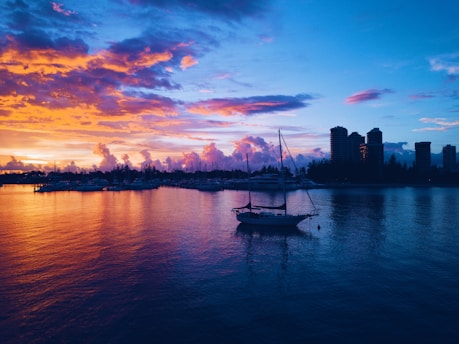 A serene landscape photograph capturing the vibrant colors of a sunset over a tranquil harbor in Hong Kong.