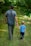 man in gray polo shirt and gray pants holding child in blue shirt