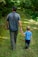 man in gray polo shirt and gray pants holding child in blue shirt