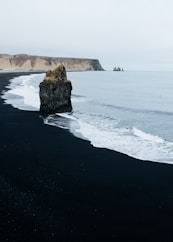 brown monolith rock on seashore
