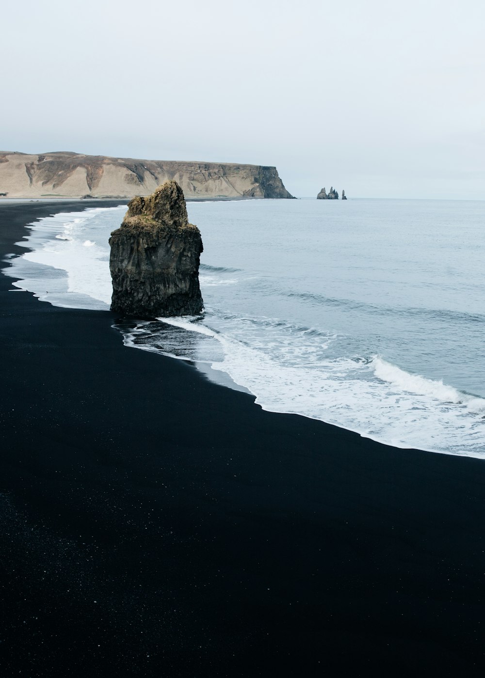 Rocher monolithe brun sur le bord de mer