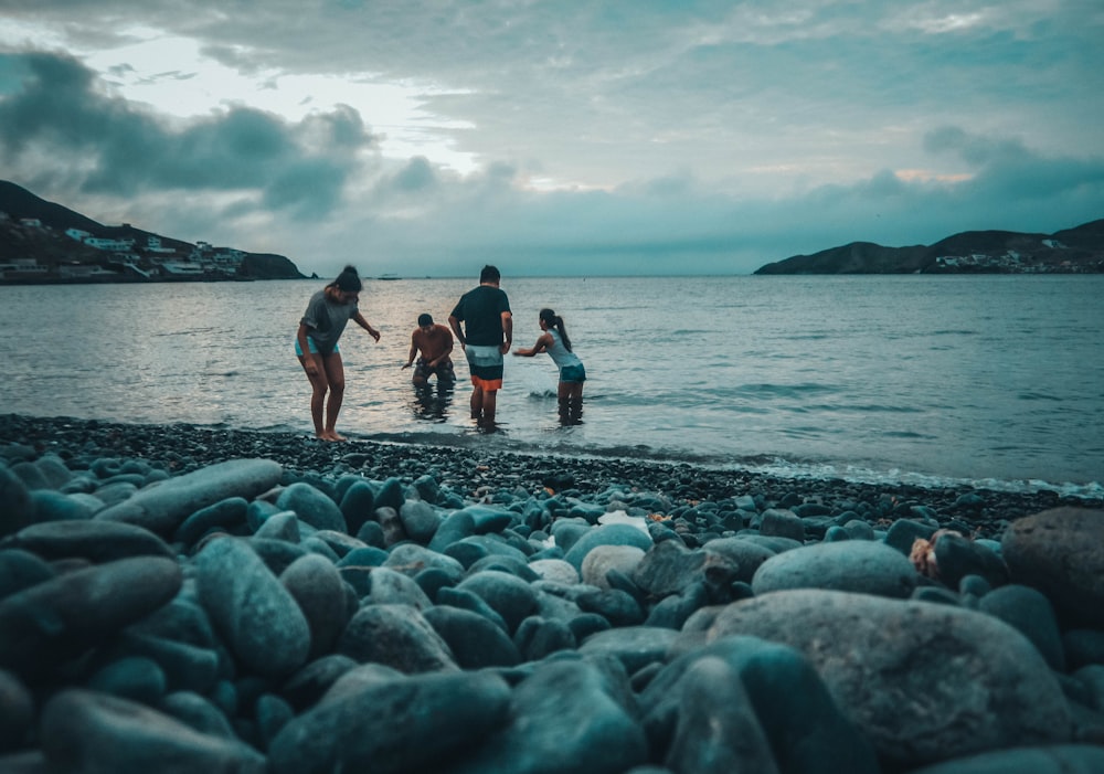 four people playing on body of water