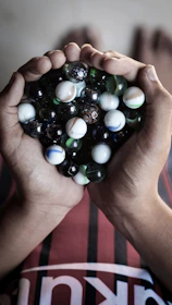 Hands gently holding a marbled crayon gear, showcasing intricate swirls of recycled colors.