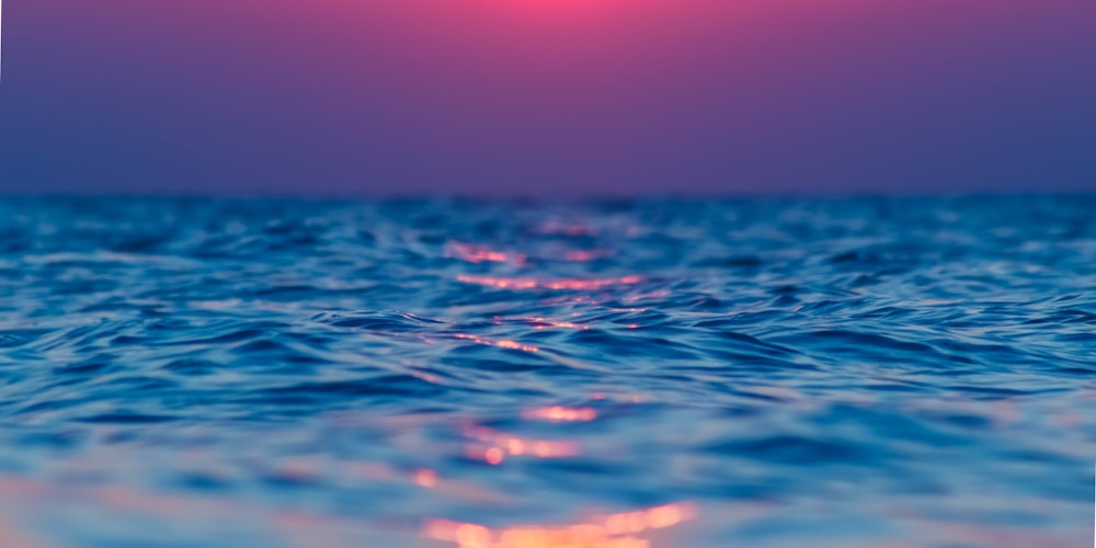 calm body of water under blue sky