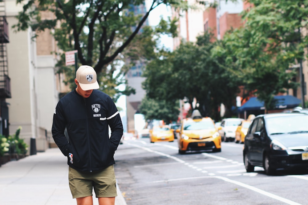 hombre que camina por el camino manos en la bolsa de la chaqueta