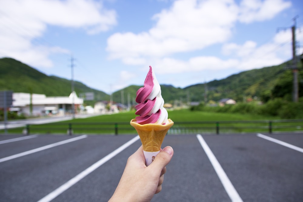 イチゴとバニラのアイスクリームをコーンに乗せた人