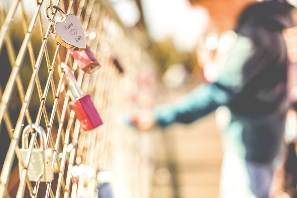 a person standing next to a wall covered in padlocks