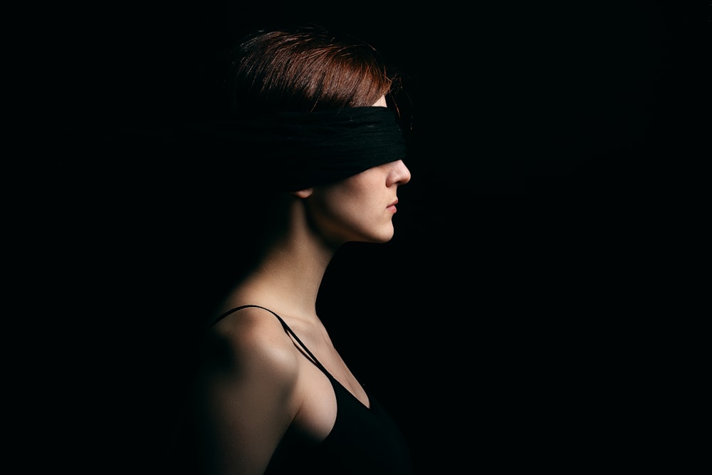 woman wearing black blindfold facing sideways