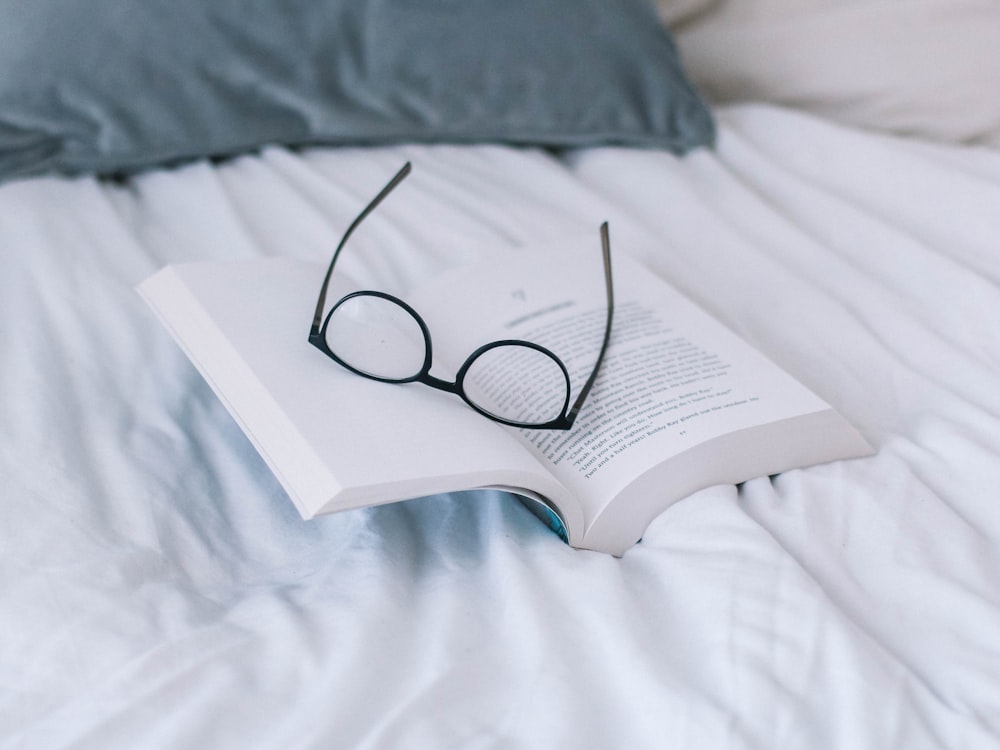 gafas de montura negra en la página del libro