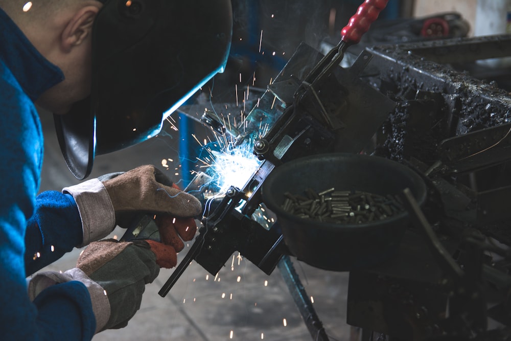 man welding a black metal