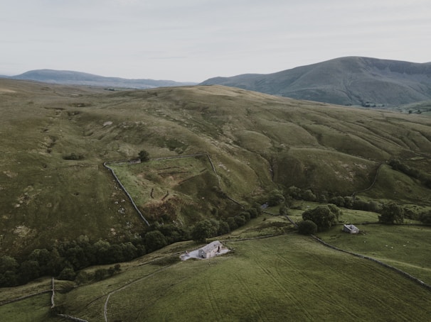 Spacious countryside farmhouse surrounded by rolling green fields.