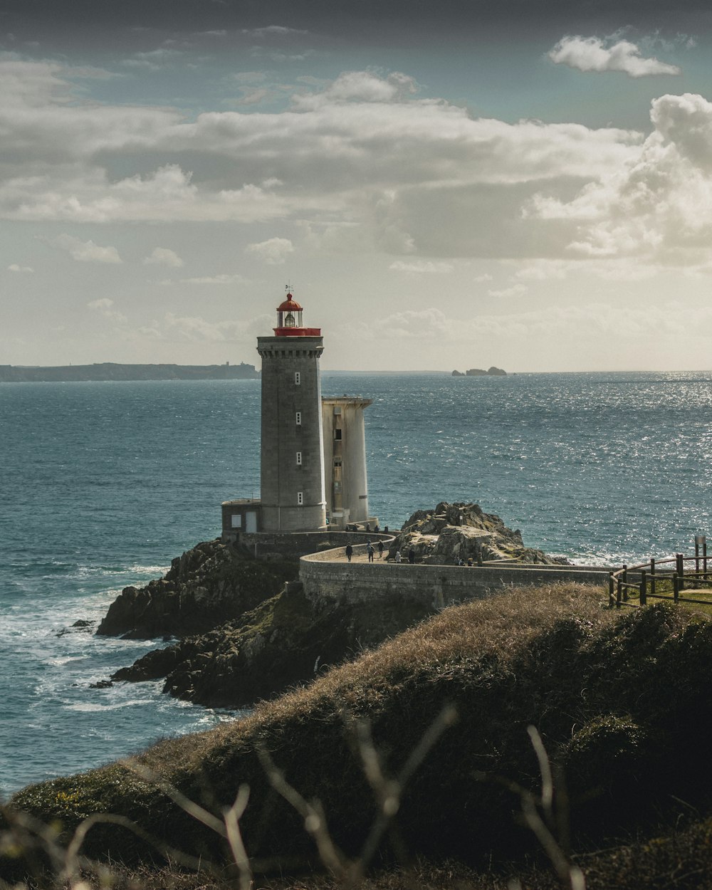 white and grey light house under blue sky during daytime