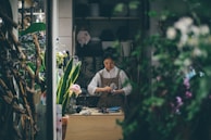 Alida Moncada carefully measuring master plants at her rustic workspace surrounded by lush green Amazonian foliage.