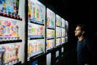 A cheerful person reaching for a bottled detox drink from the vending machine.