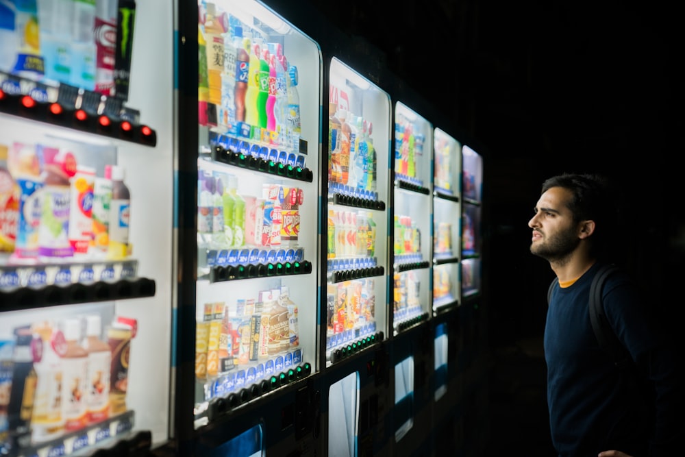 夜間、自動販売機の前にいる男性